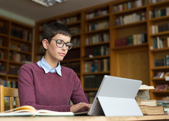 Person working on a laptop in a library